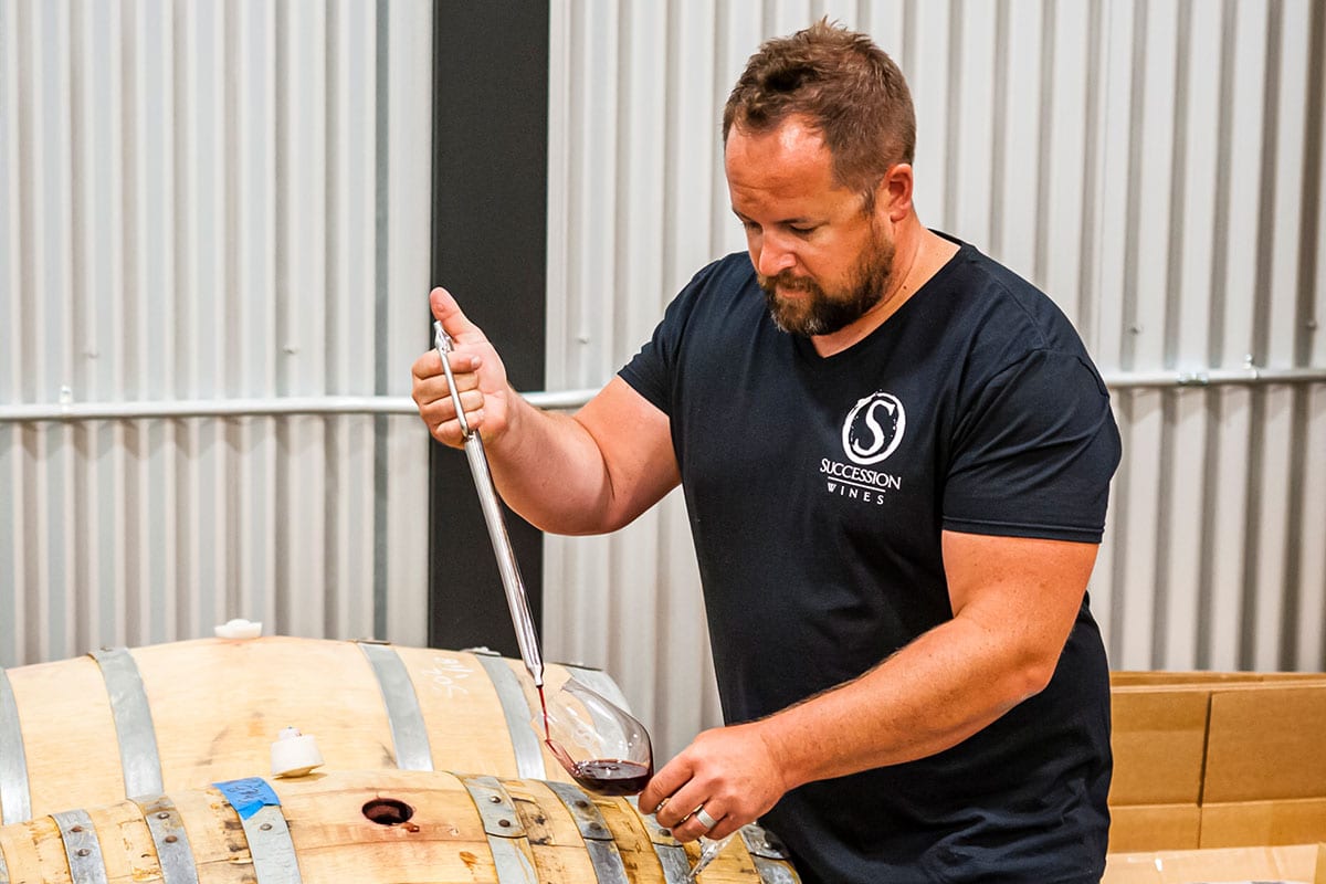 Brock Lindsay tasting the wine from barrel