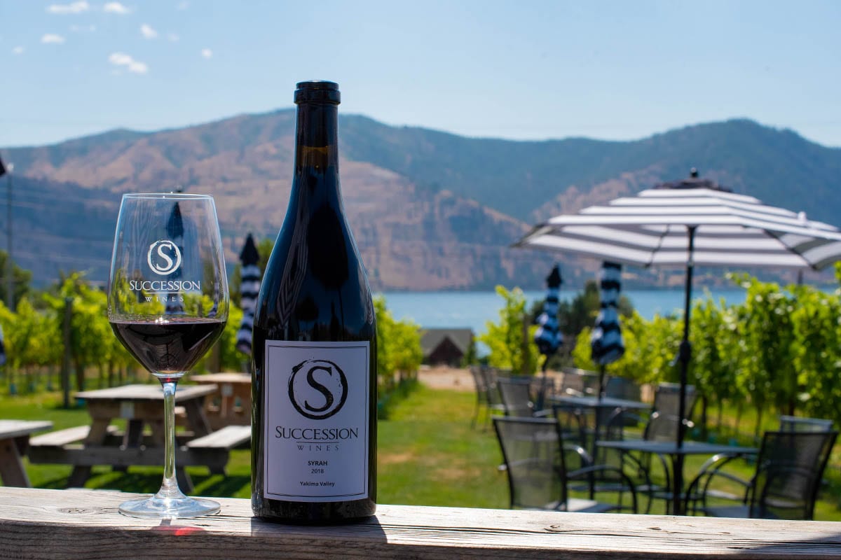 wine bottle and glass overlooking lake