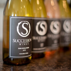 Lineup of Succession wine bottles with a closeup of the bottle label