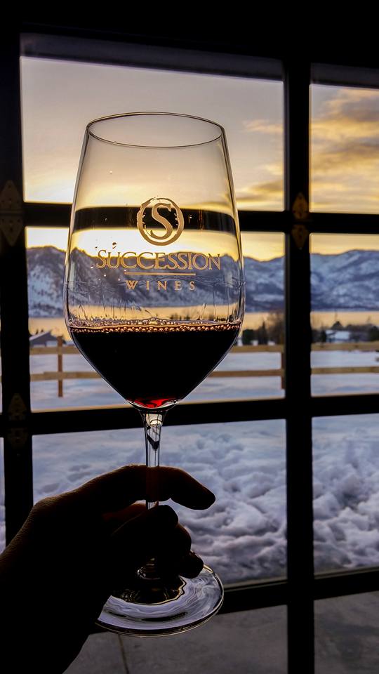 Glass of Succession wine with a snowy landscape beyond